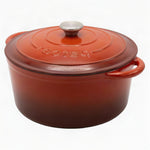 Red enameled cast iron Dutch oven with a lid on a white background