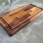 Wooden cutting board with a logo on a concrete surface