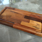 Wooden cutting board with a logo on a gray surface