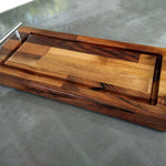 Wooden cutting board with metal handles on a gray surface