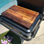 Wooden cutting board on a grill by a poolside